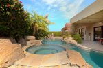Pebble tech spa with spillover waterfall into pool
